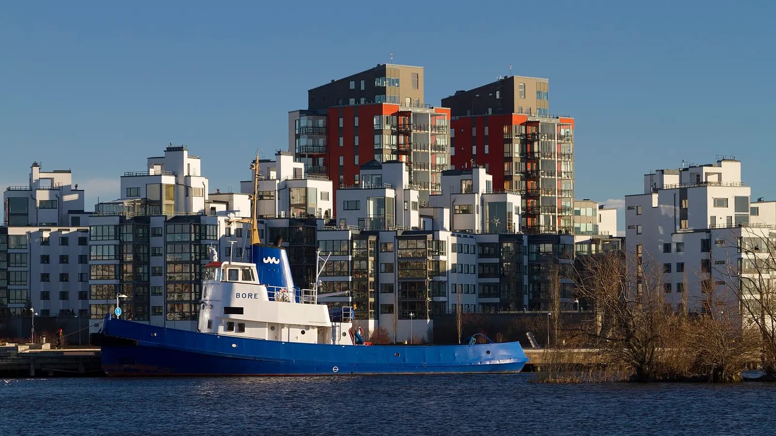 Nybyggda flerbostadshus vid Öster Mälarstrand i Västerås, med en båt i förgrunden